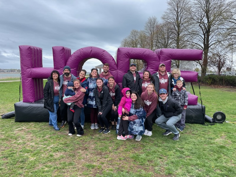 A small group in front of a MMRF Hope inflatable sign.