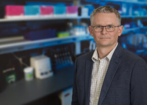 a portrait of jonathan keats phd in his lab at TGen