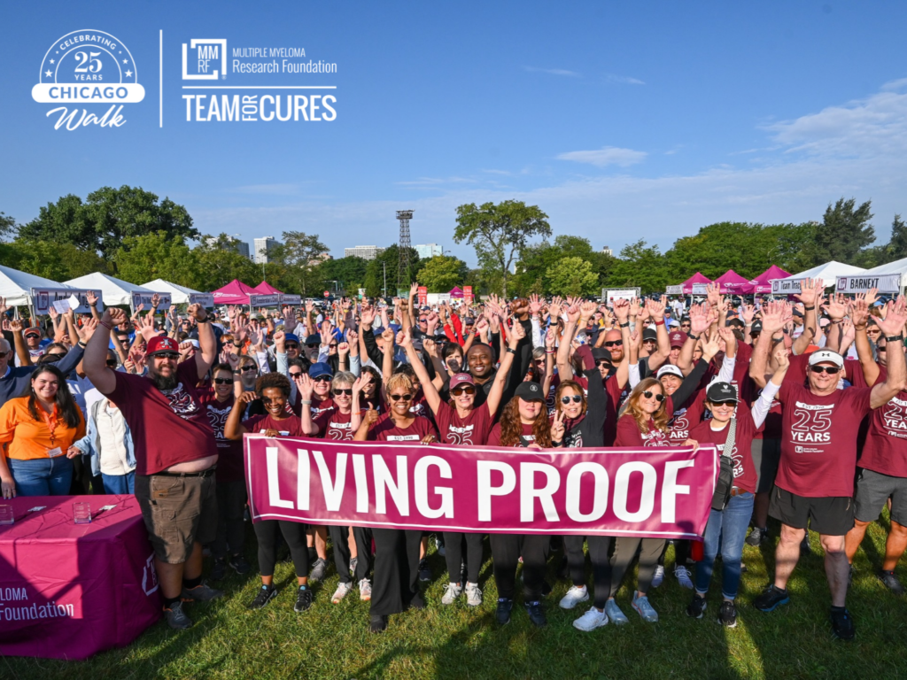 Participants at an MMRF Chicago Walk wearing maroon and posing with a sign that reads LIVING PROOF